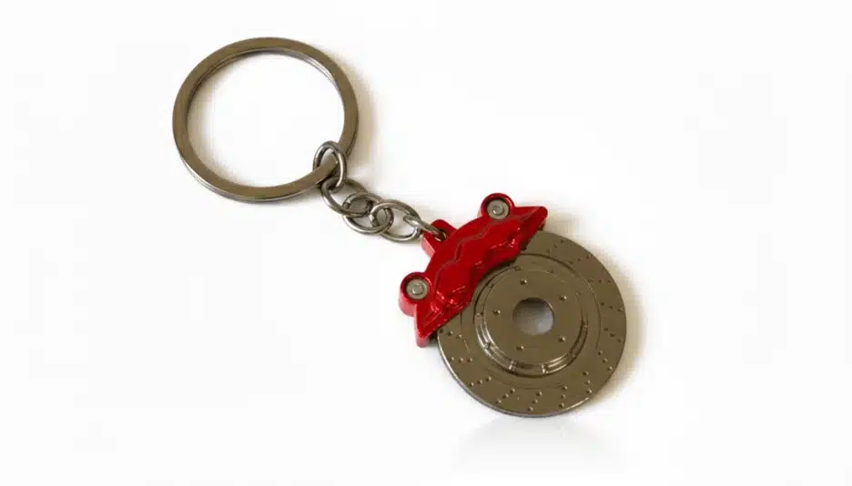 A miniature brake disc keychain with a red calliper.