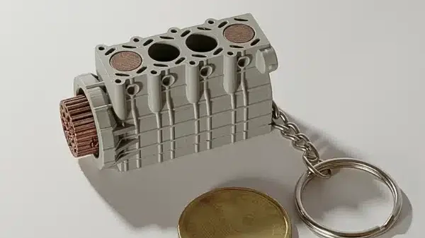 Lightweight 4-cylinder engine automotive keychain designed for car enthusiasts.