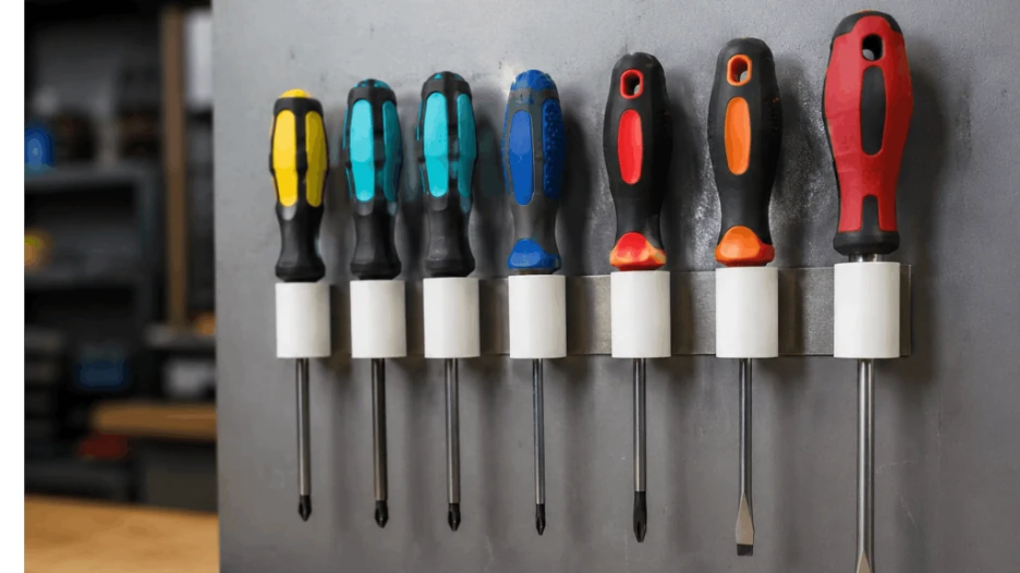 Screwdrivers held upright in a DIY wall mounted screwdriver holder.